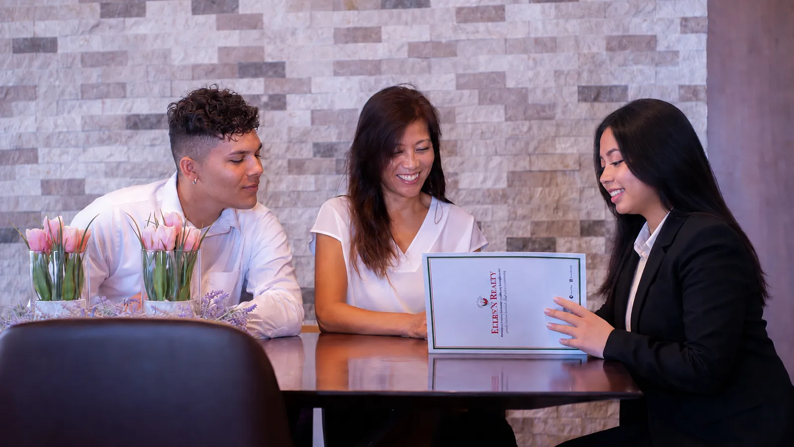Ellen's Realty agents going through an agreement together at the Tamuning office